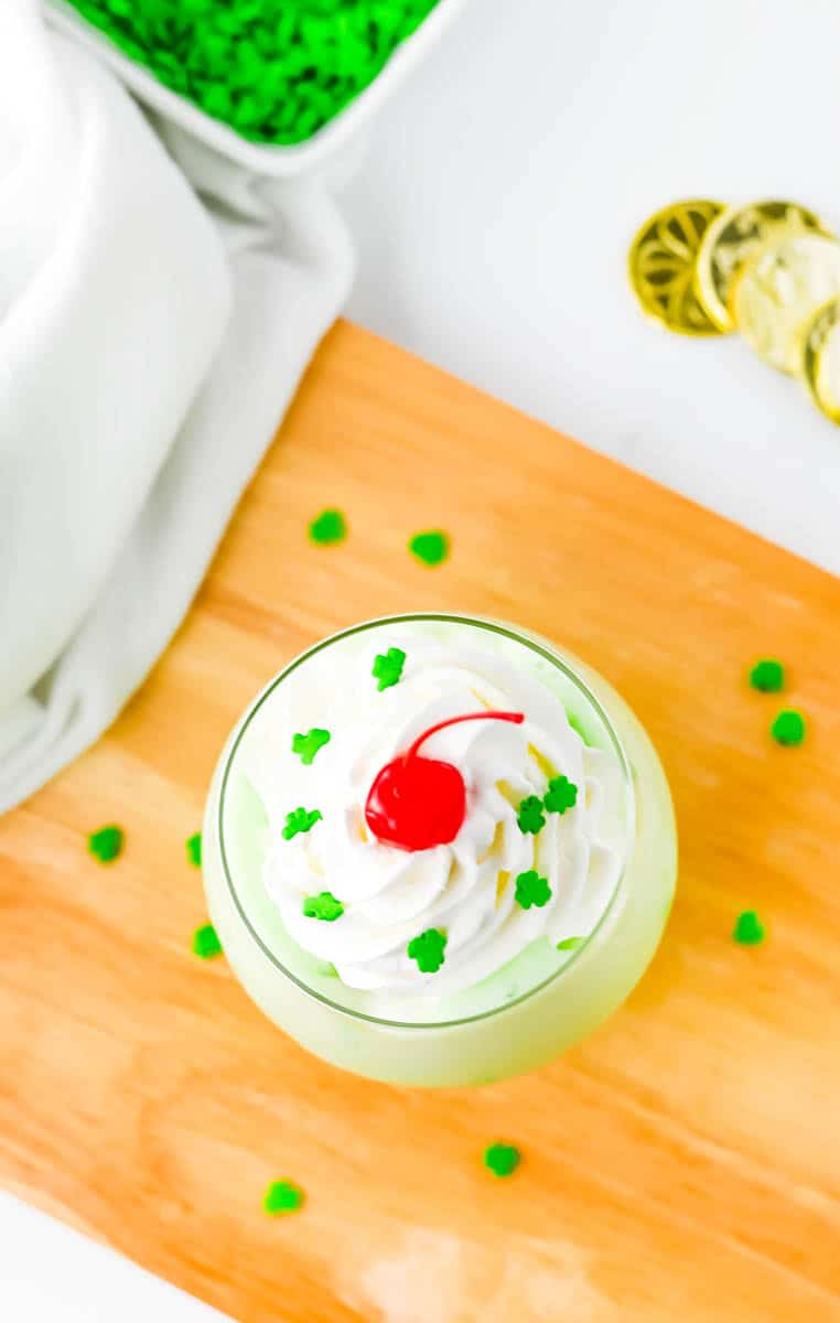 Overhead shot looking down on shamrock shake thats on a wood board