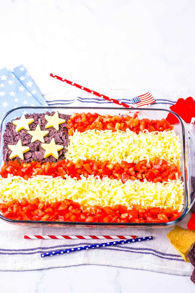 American Flag Taco DIp finished in baking dish and surrounded by patriotic decorations.