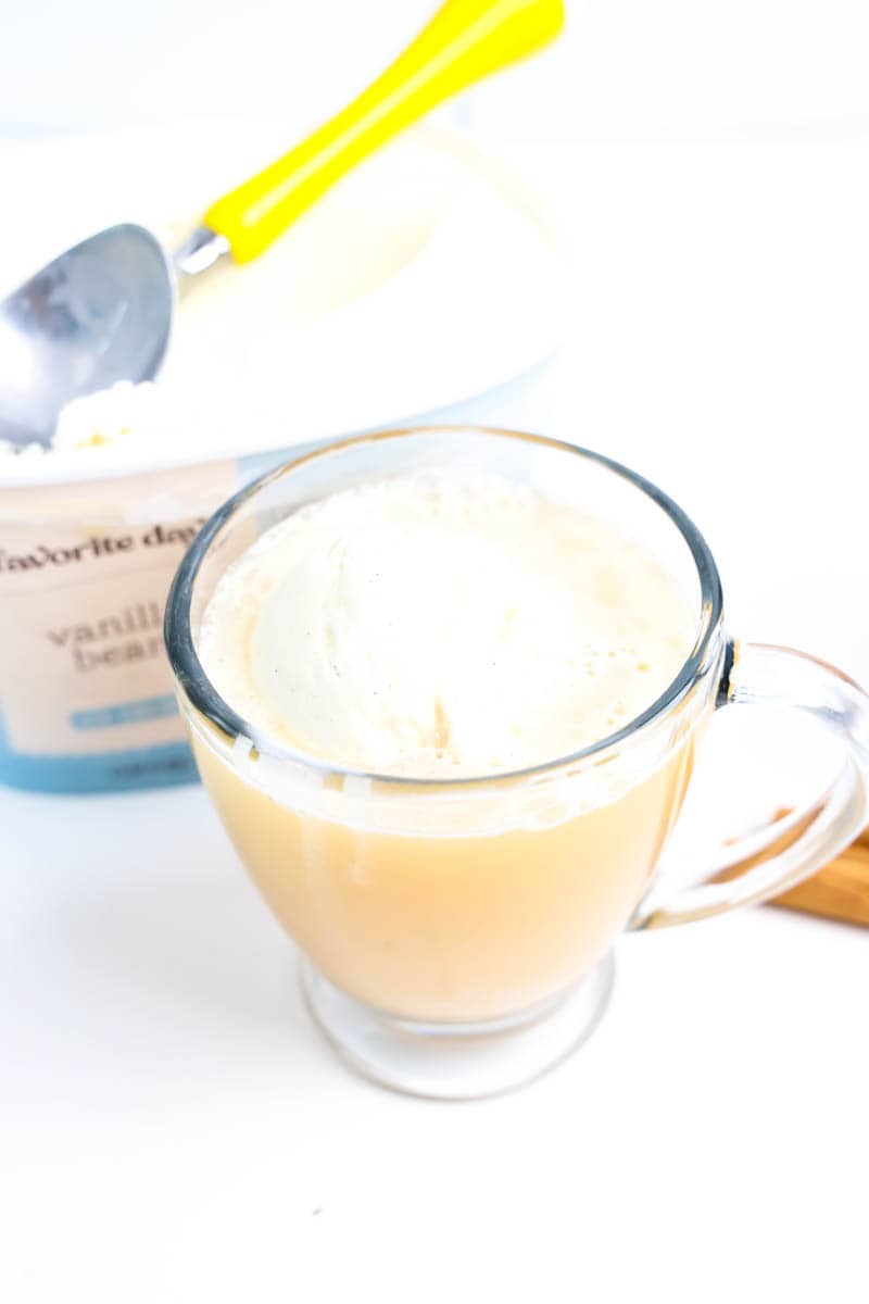 Clear glass with apple cider on top of ice cream
