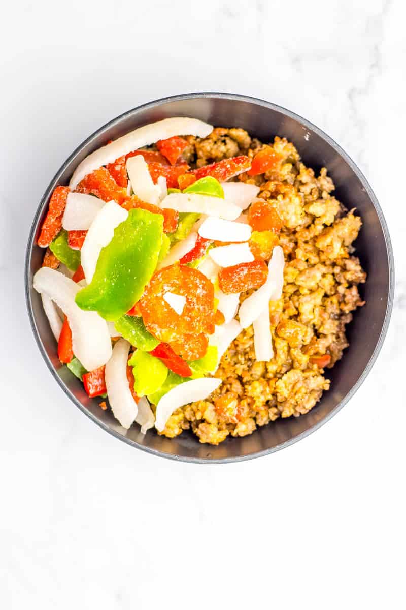Bowl with sausage, pepper and onions mixed together.