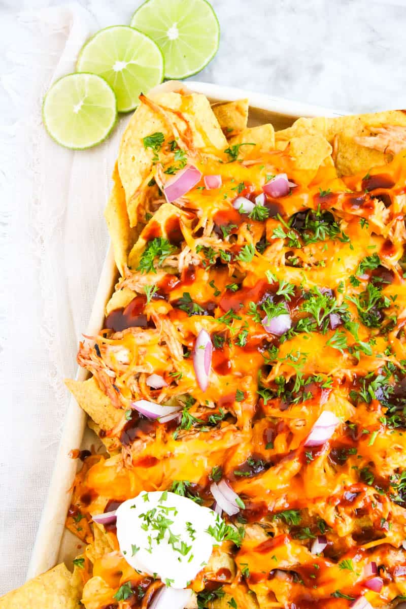 Left corner shot of sheet pan bbq chicken nachos on marble background.