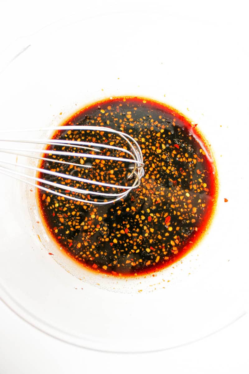 Clean bowl with marinade ingredients and a whisk.