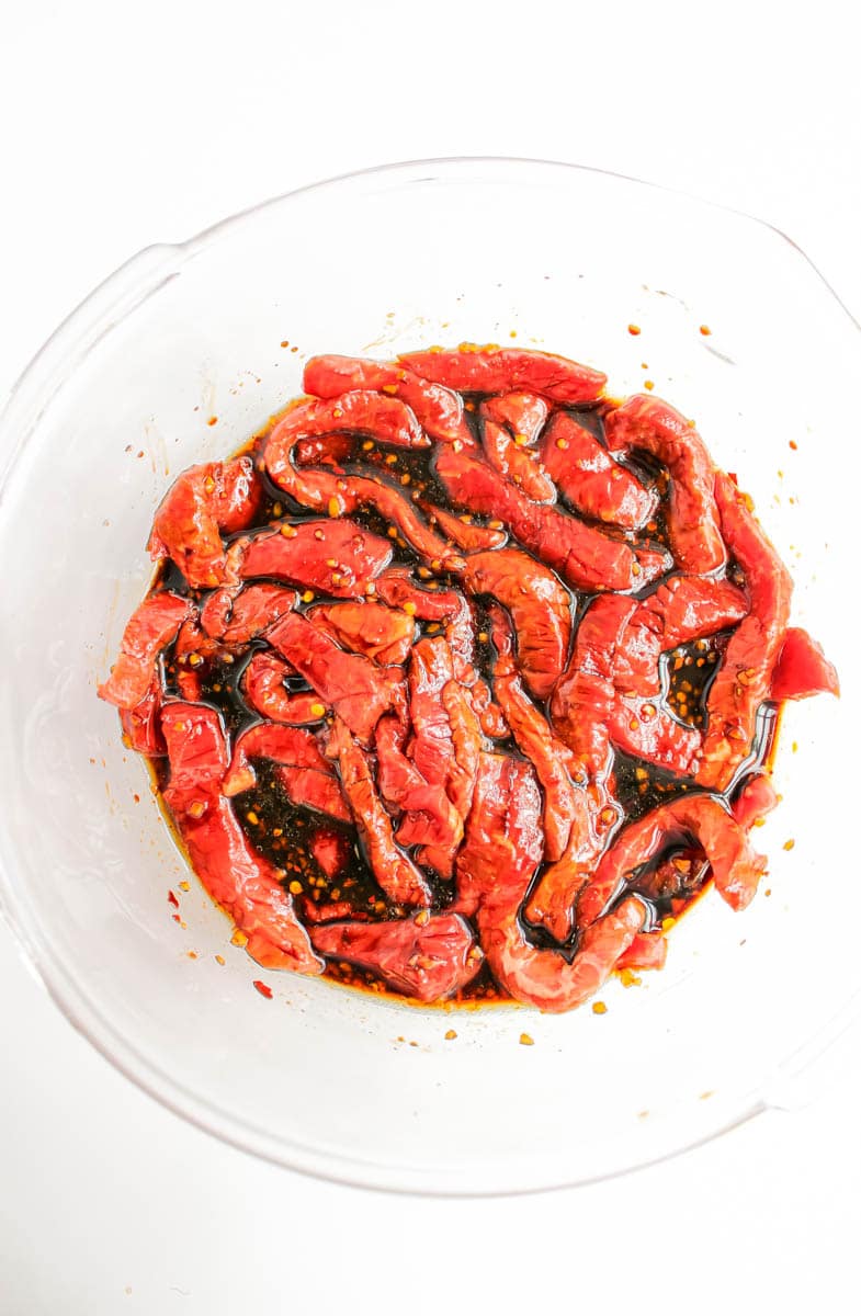 Clean bowl with marinade and steak strips.