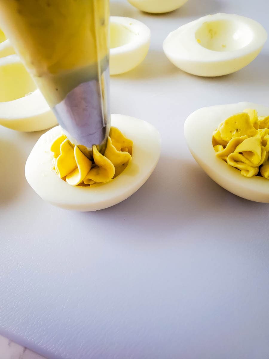 A piping bag filling the white portions of the eggs.