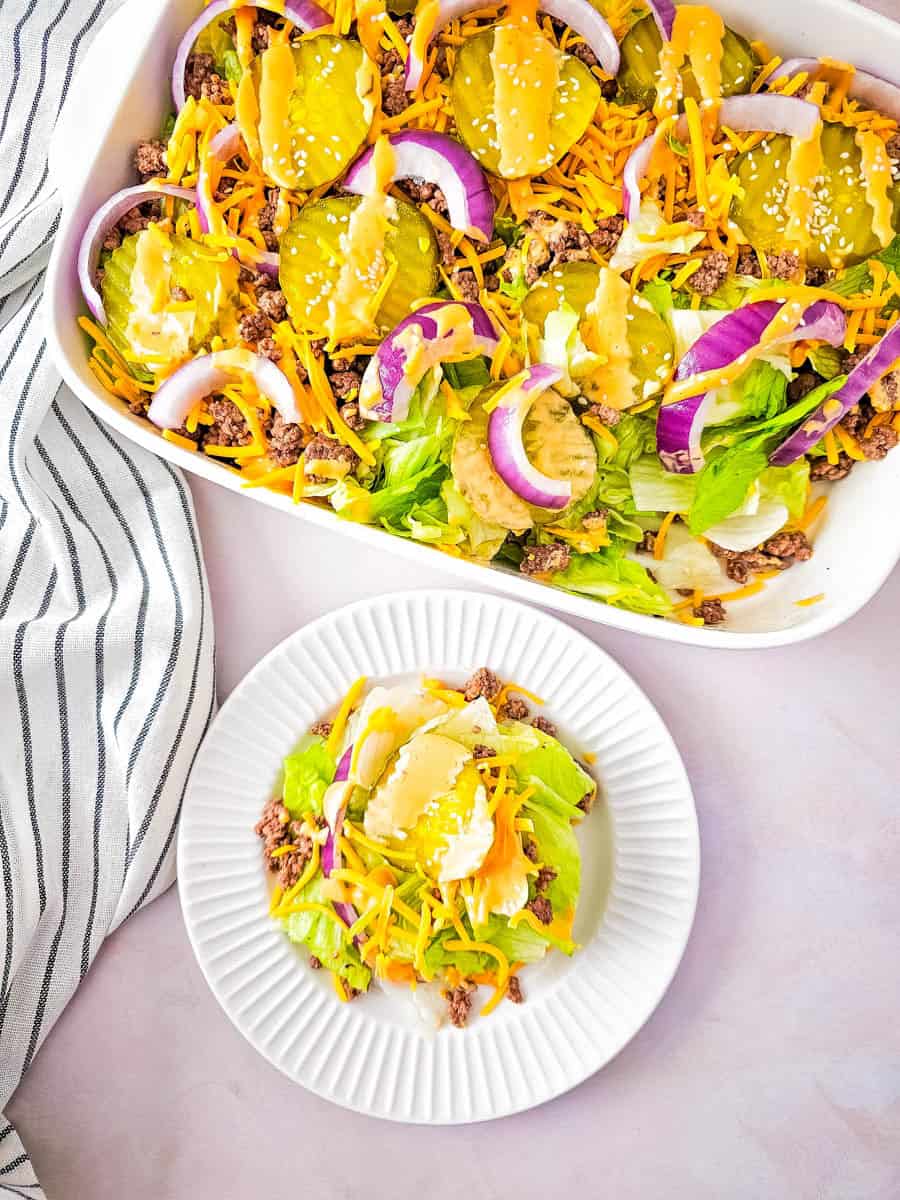 Big Mac salad in casserole dish with plated salad beside on white plate