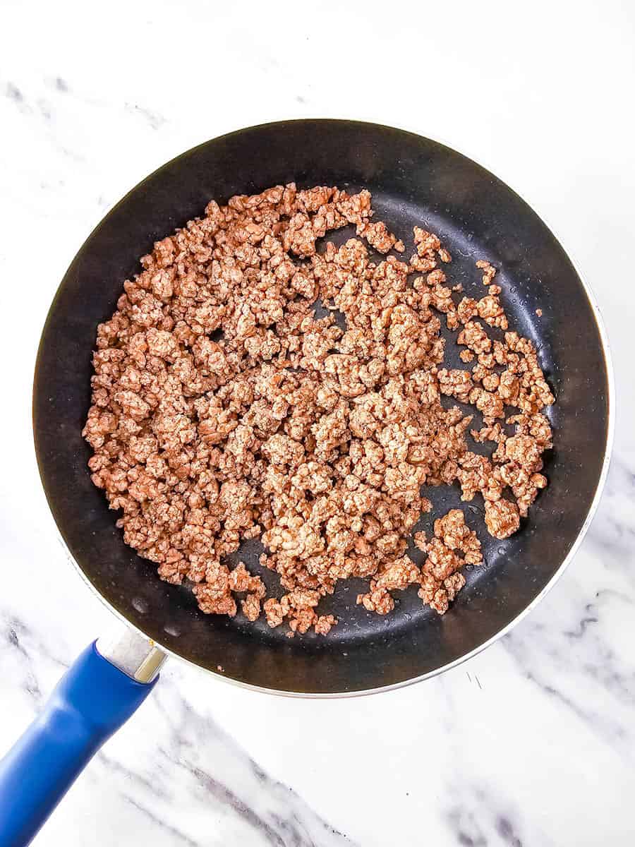 Frying pan with cooked ground beef.