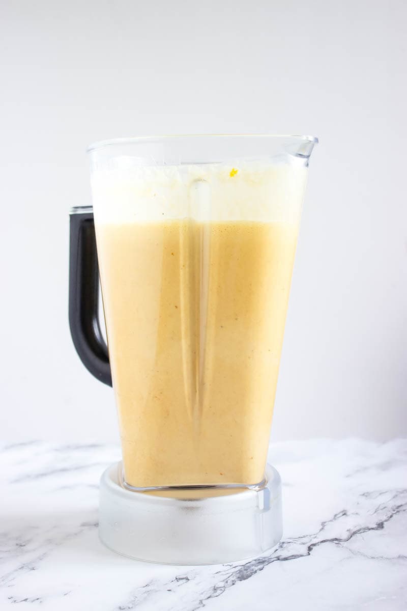 Blended ingredients for pumpkin spice eggnog in the blender.