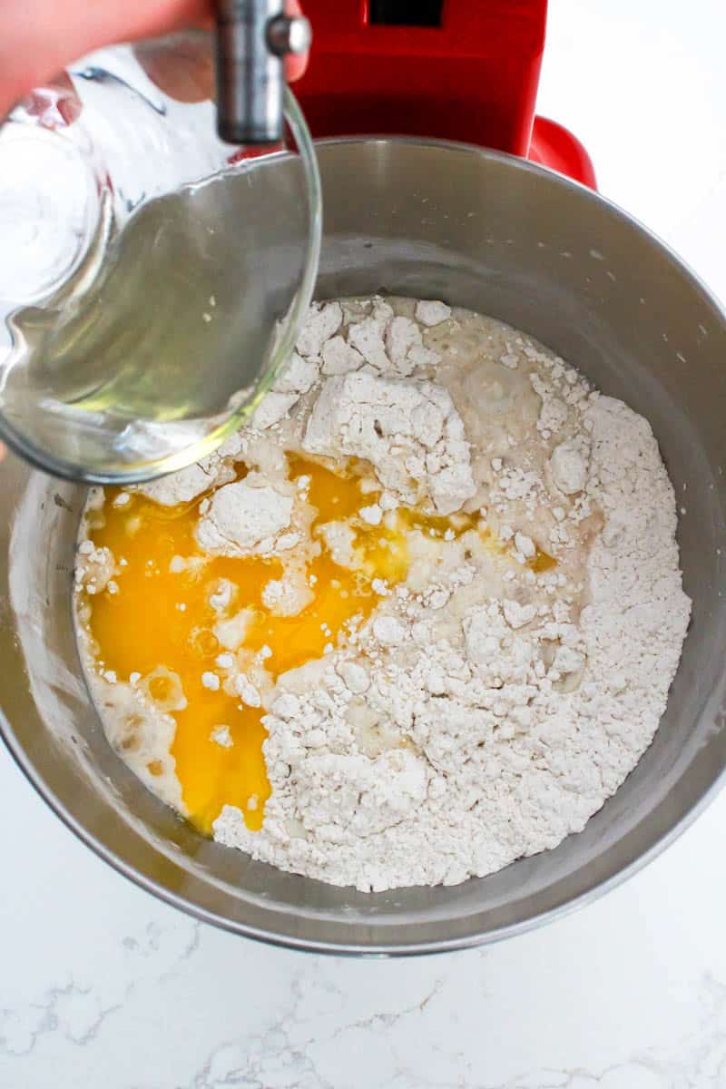 Wet ingredients being combined with the dry ingredients for dinner rolls