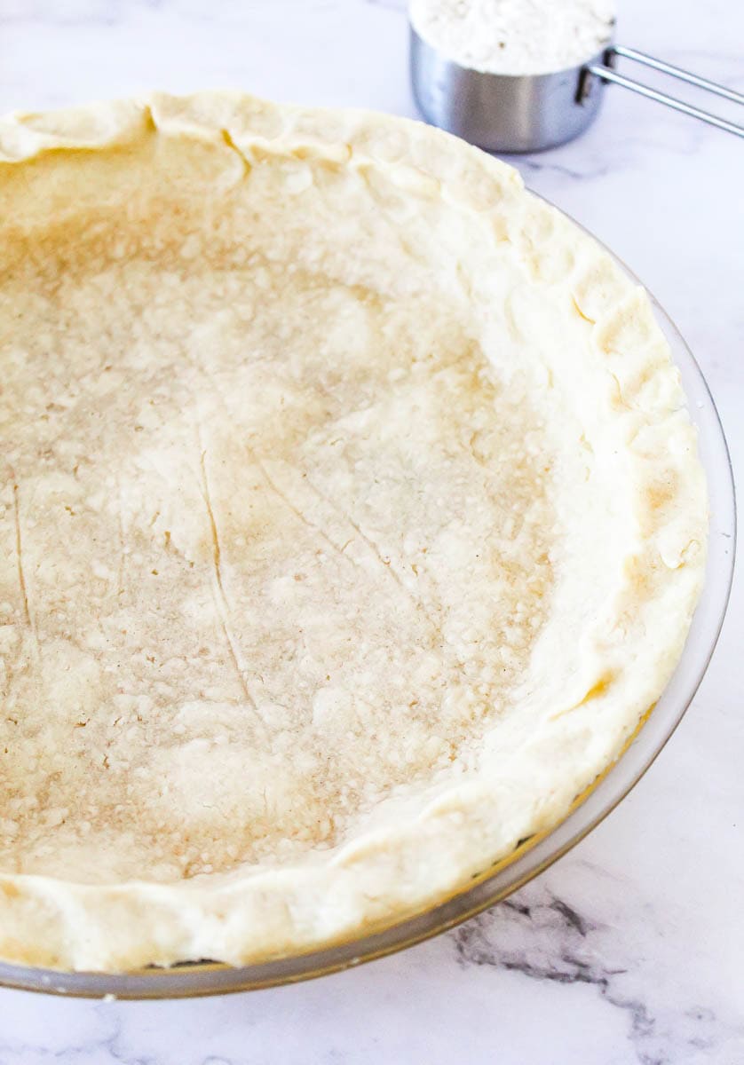 Pie crust in pie pan on marble top.