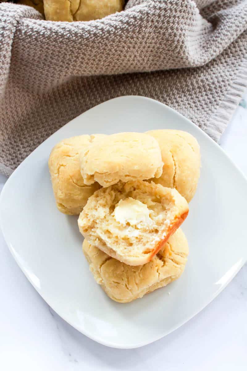 Dinner roll buttered on white plate.