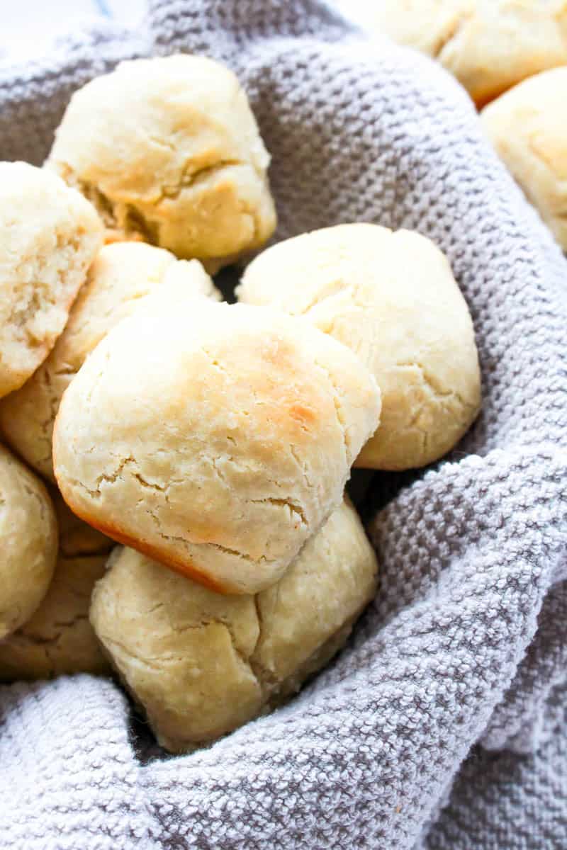 Dinner rolls in basket with a blue towel