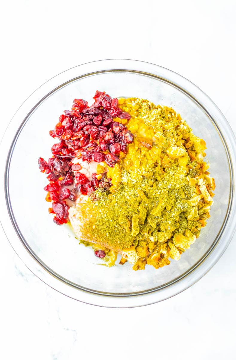 Ingredients for the stuffing balls in a clear bowl mixed together.