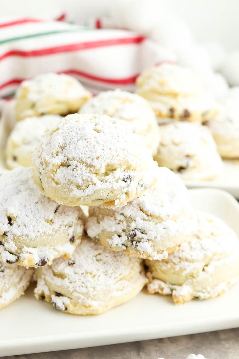Gluten free snowball cookies stacked on a white plate
