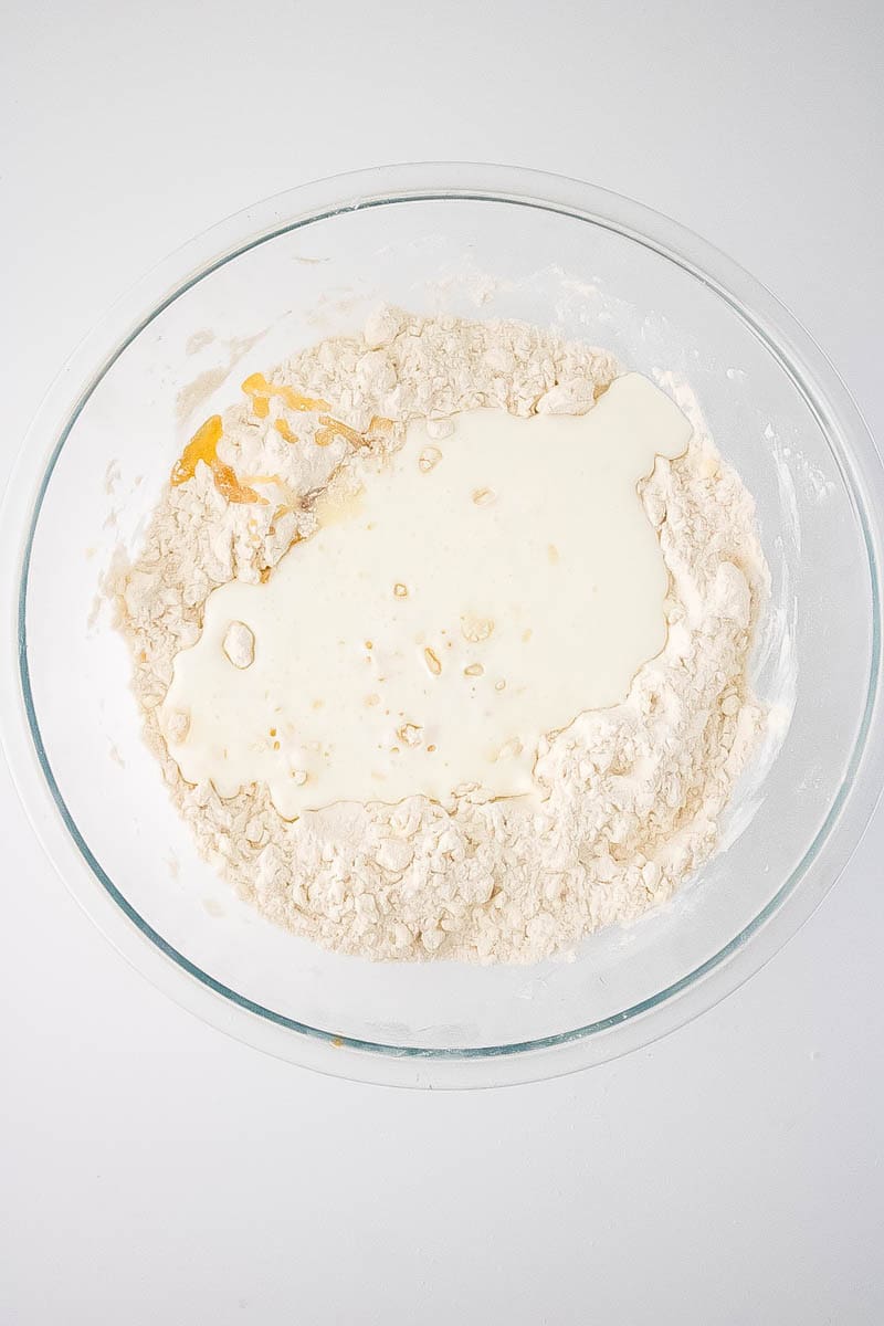 Buttermilk poured on top of flour and butter mixture to be mixed in.