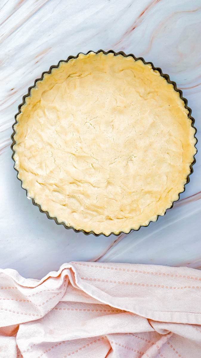 A pie crust in a pie pan on white background.