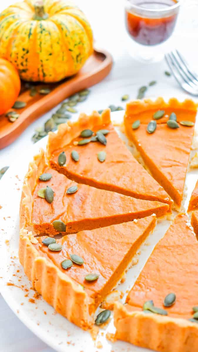 Gluten free pumpkin pie on a white plate with slices cut
