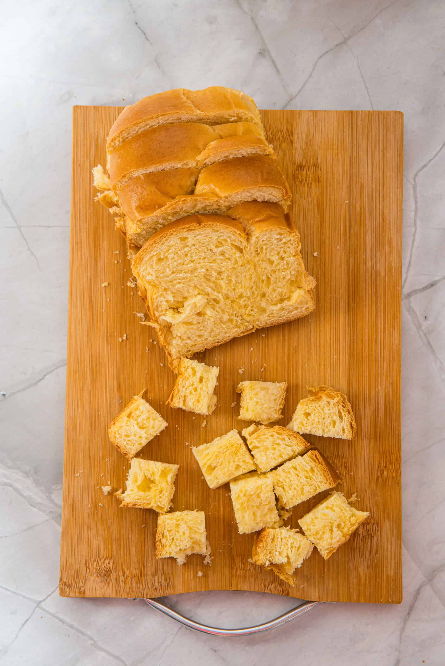Gluten Free brioche bread cut into pieces on cutting board.