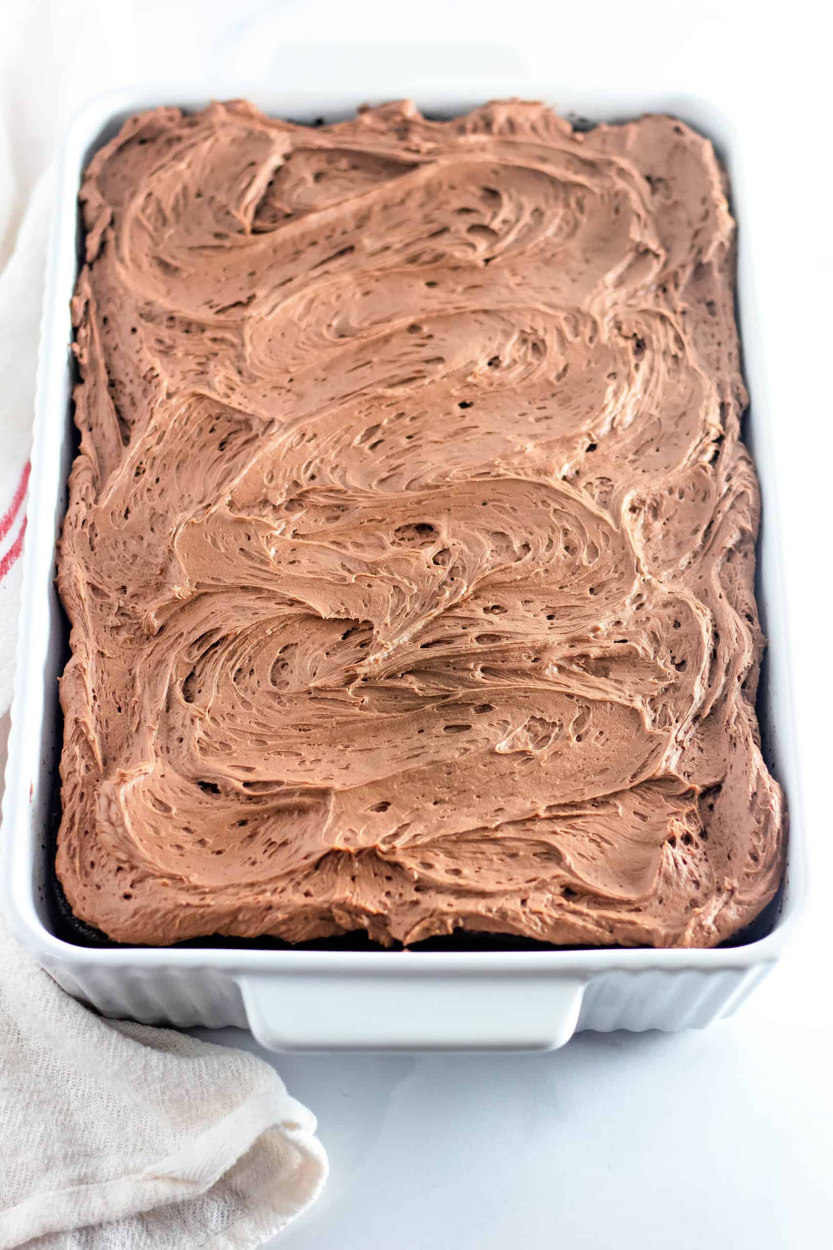 Frosted gluten free chocolate cake in a baking pan.