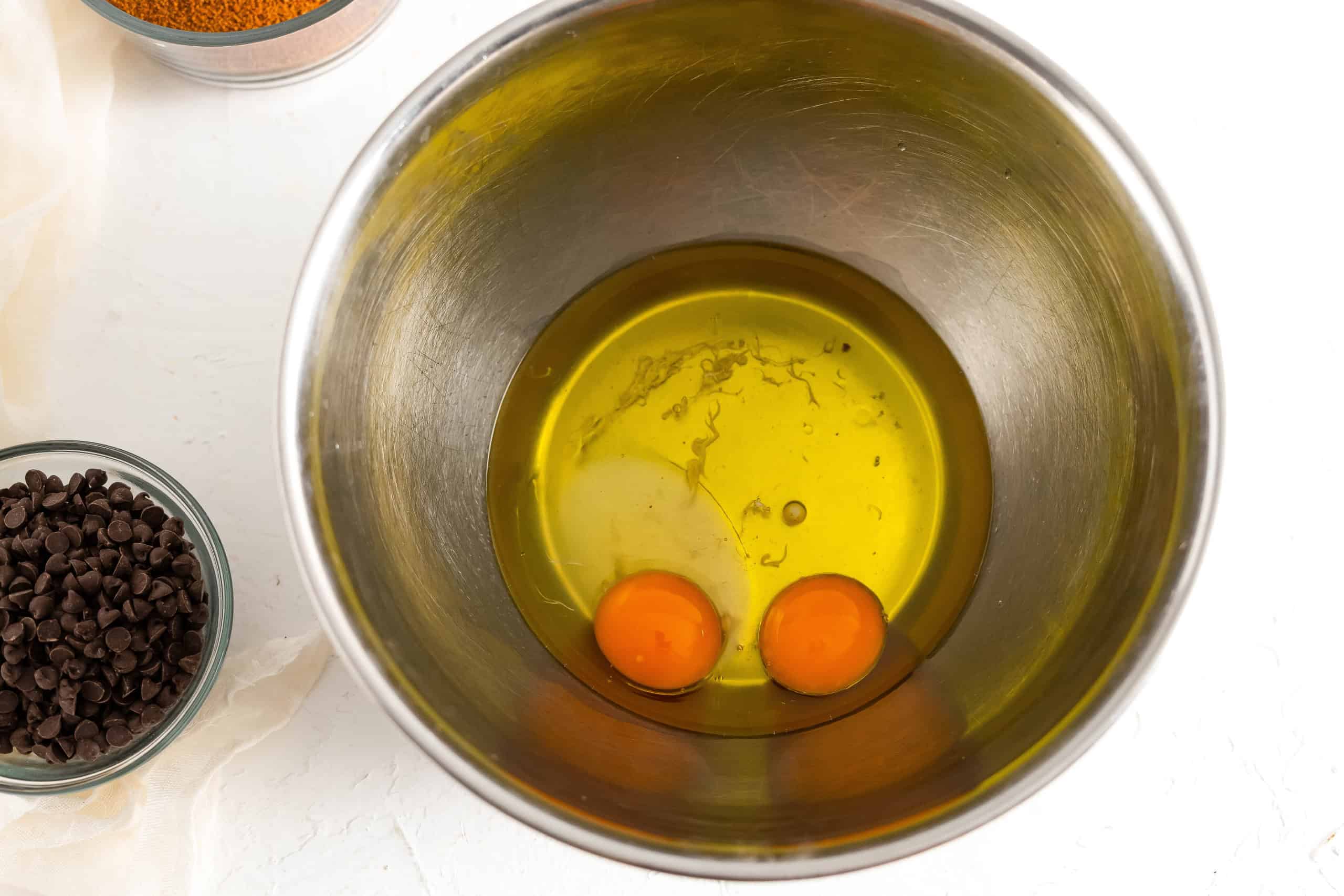 Bowl with egg, egg yolk and melted ghee to be whisked.