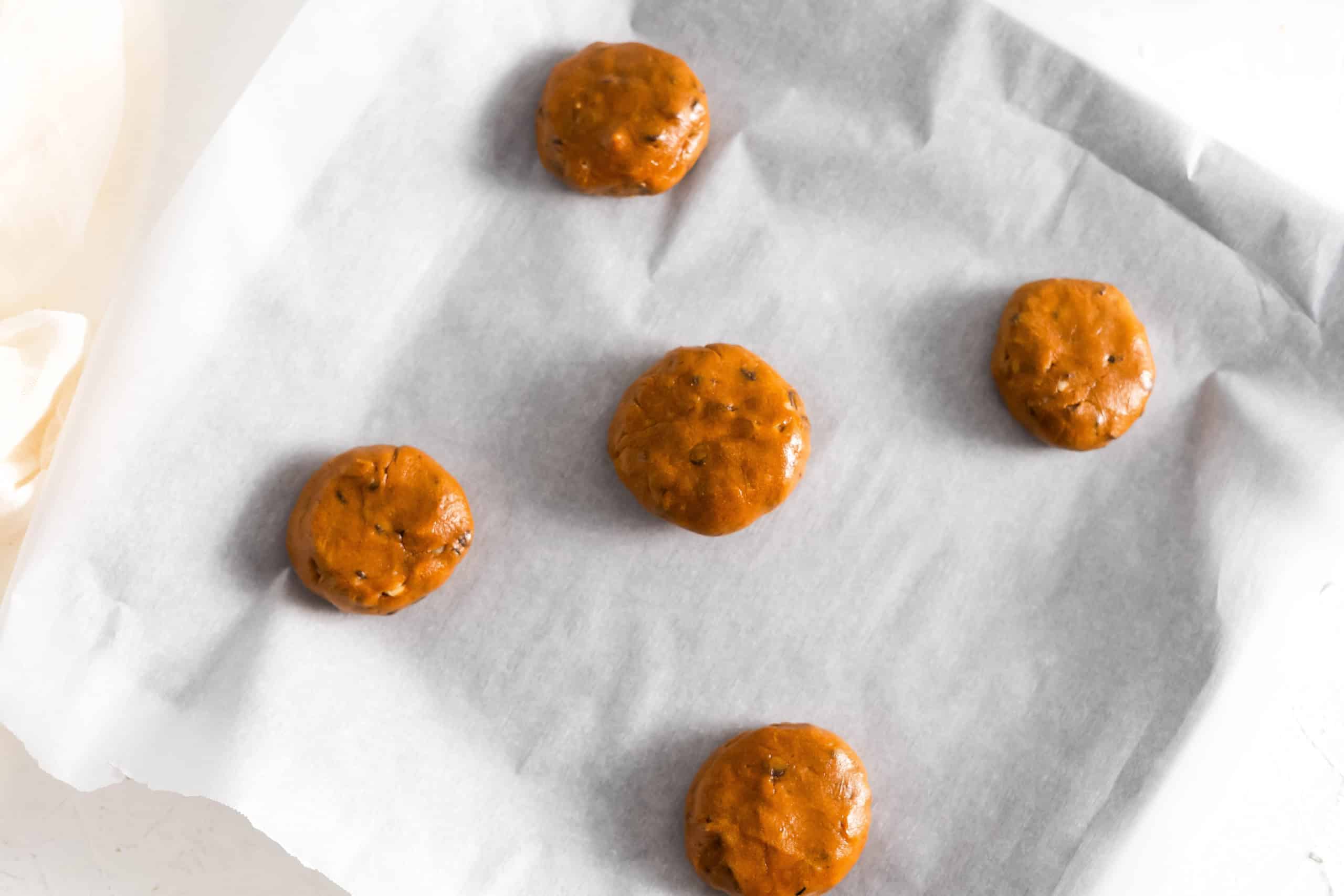 Cookies formed and pressed onto parchment paper.