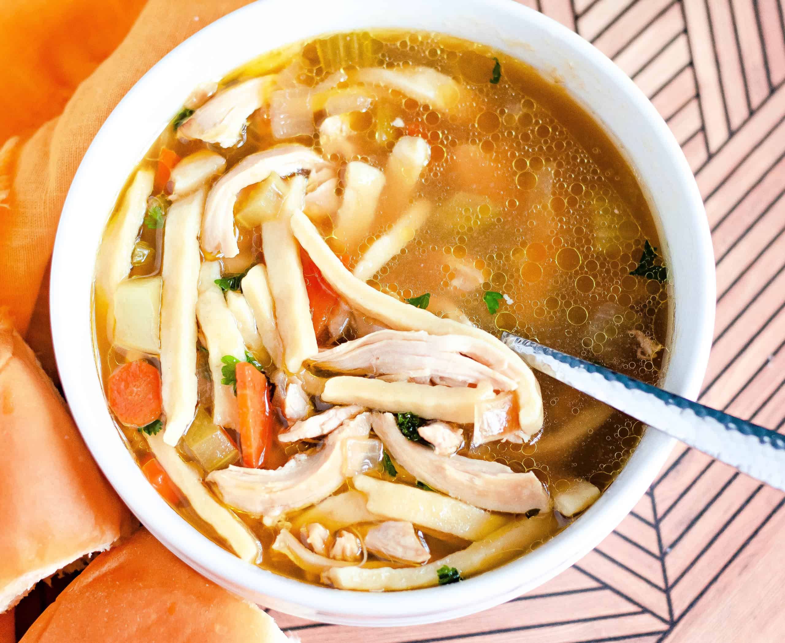 A bowl of gluten free chicken noodle soup in white bowl