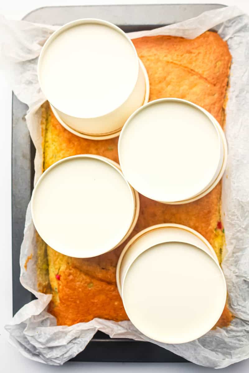 Sheet cake with dessert cups upside down on it.