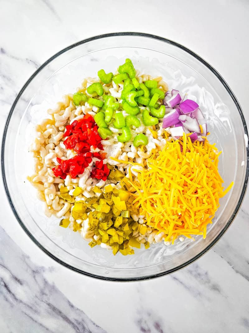 Bowl with cheese, pimento, celery, onion on top of macaroni