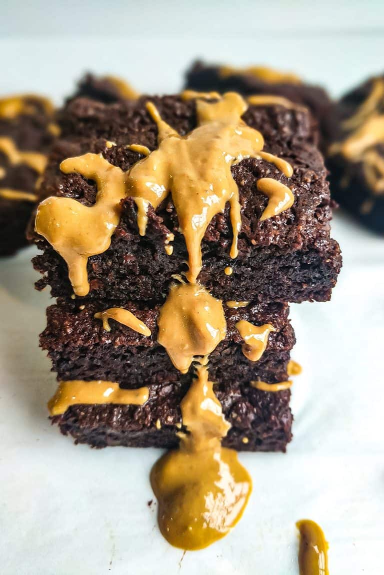 Tower of three chocolate brownies with cashew butter dripping off