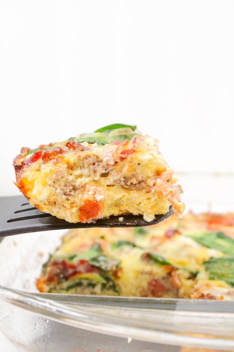 Piece of frittata being lifted with spatula off plate.