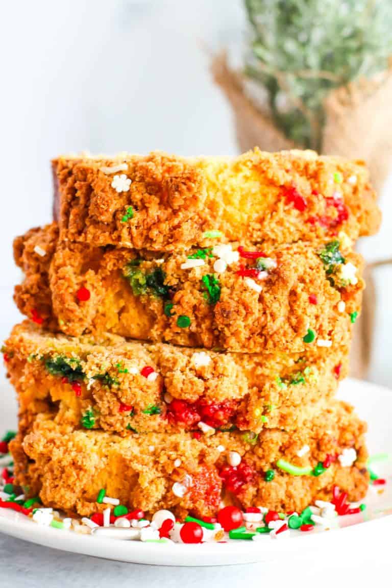 Eggnog bread stacked 4 pieces high with greenery in the background