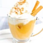 Apple Cider Float in a clear glass on a white towel with gray stripes on a gray/white background.