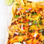 Left corner shot of sheet pan bbq chicken nachos on marble background.