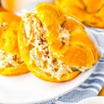 Salad on croissant bread on white plate