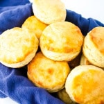 Gluten free buttermilk biscuits in a pan sitting on a blue towel.