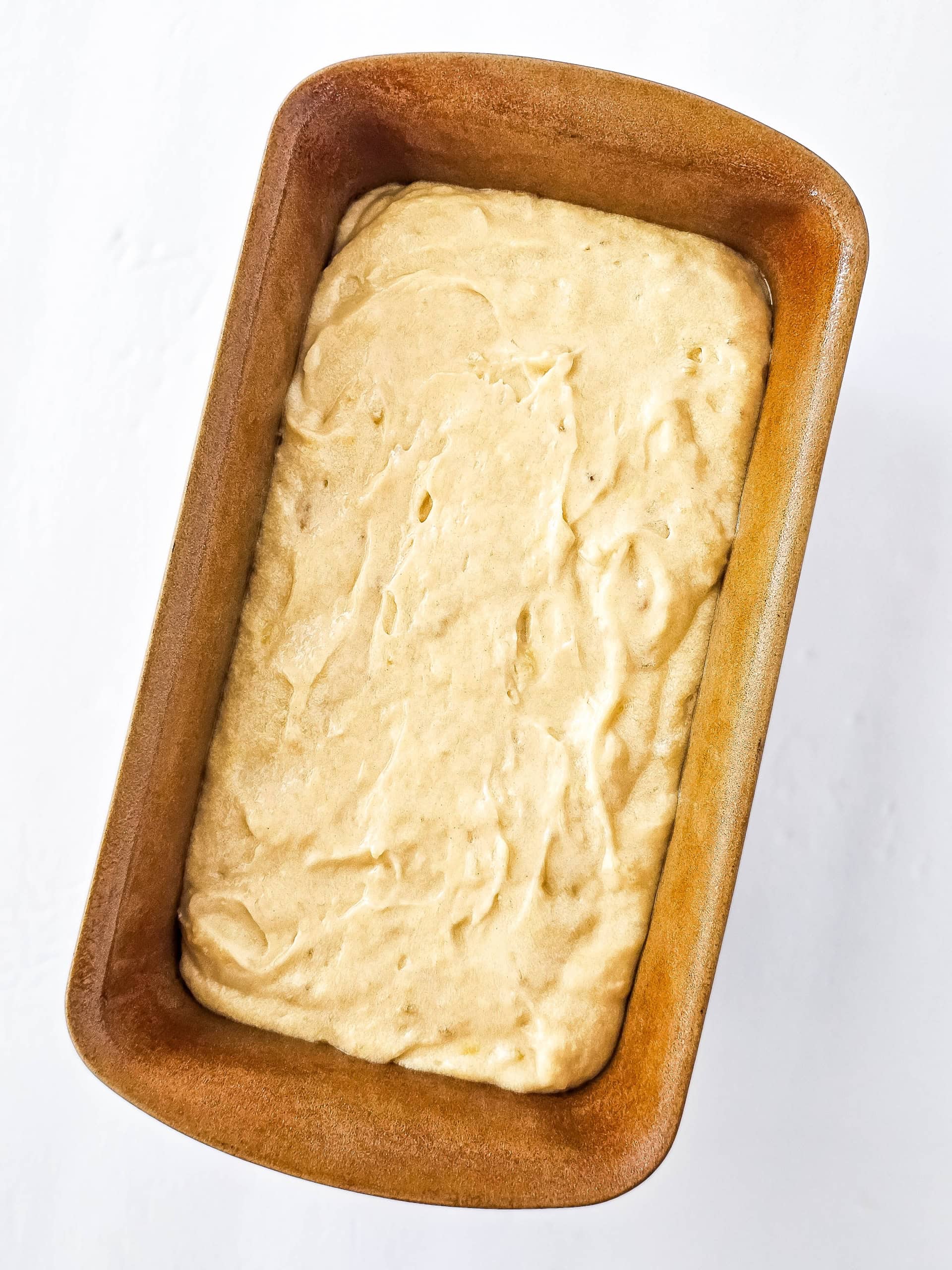 Banana bread batter poured into a loaf pan.