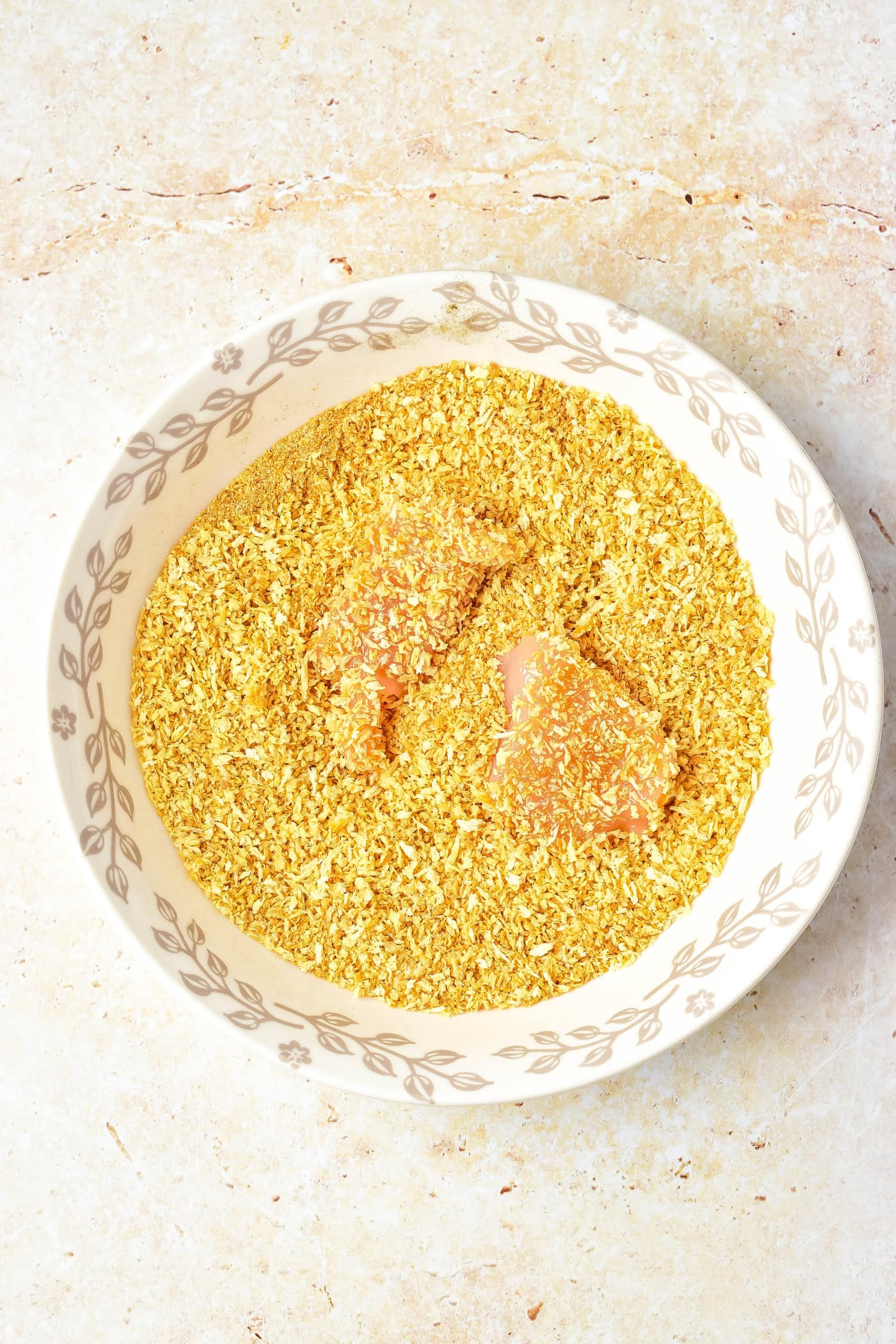Chicken breaded in breadcrumbs in a white bowl