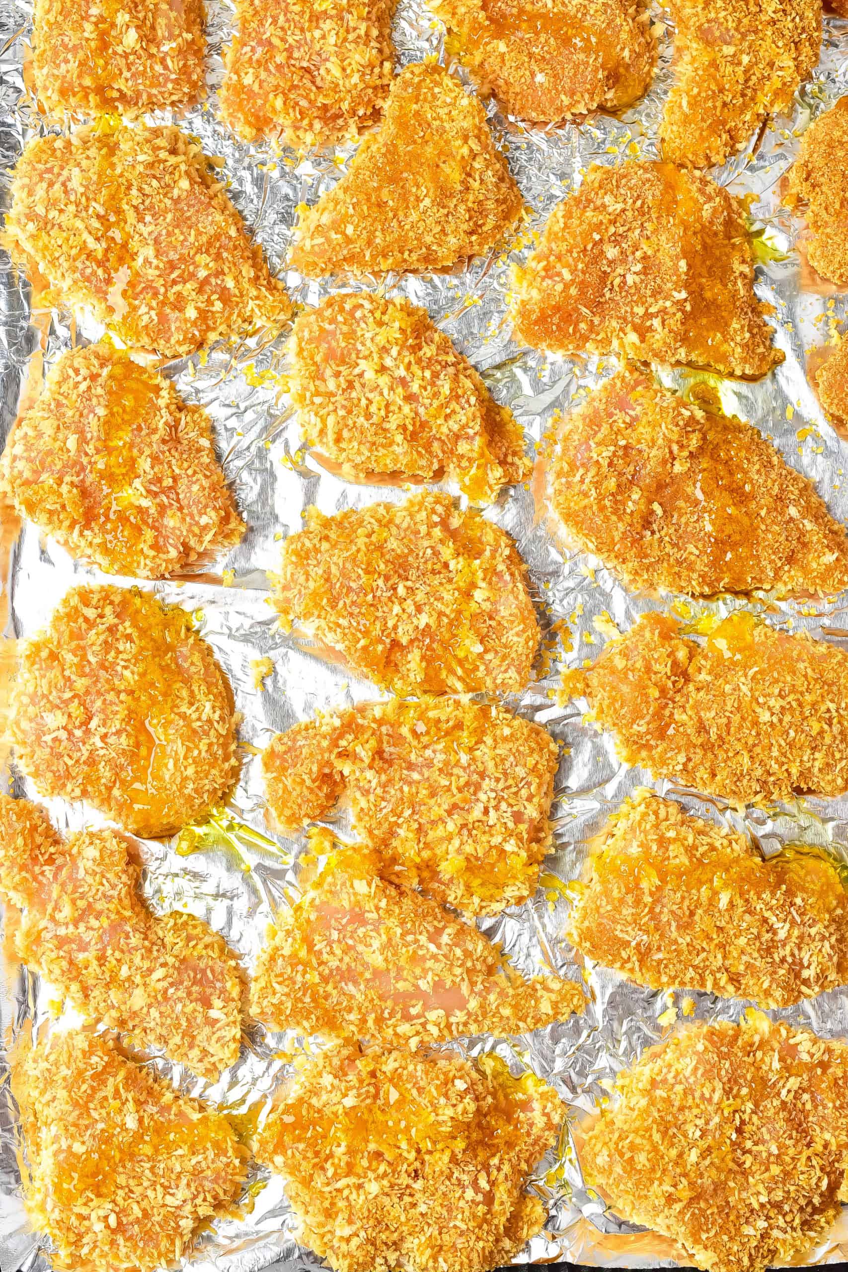 Breaded chicken pieces on baking sheet