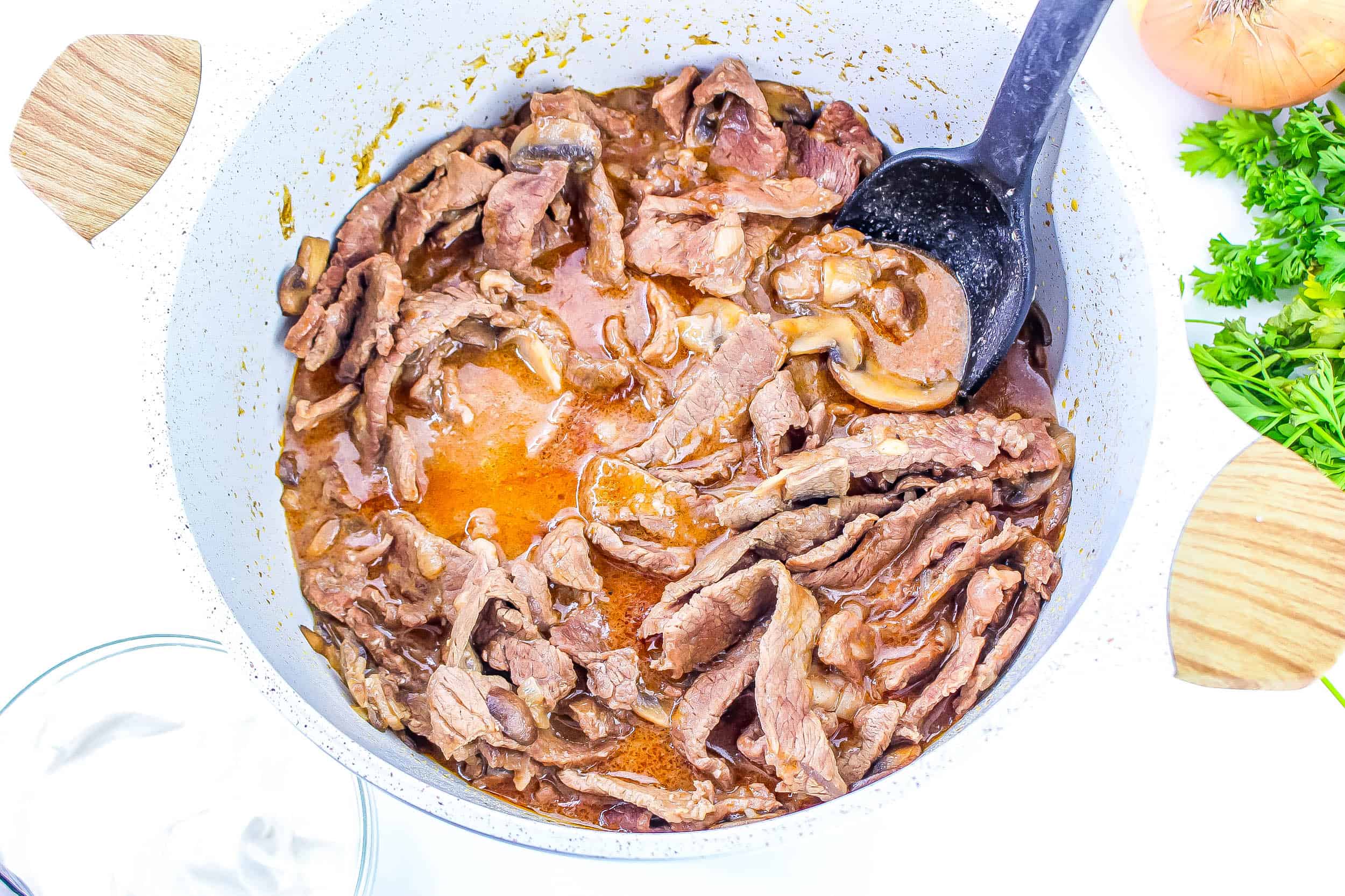 Beef added into sauce in dutch oven