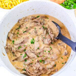 Gluten free beef stroganoff in the white dutch oven with black spoon