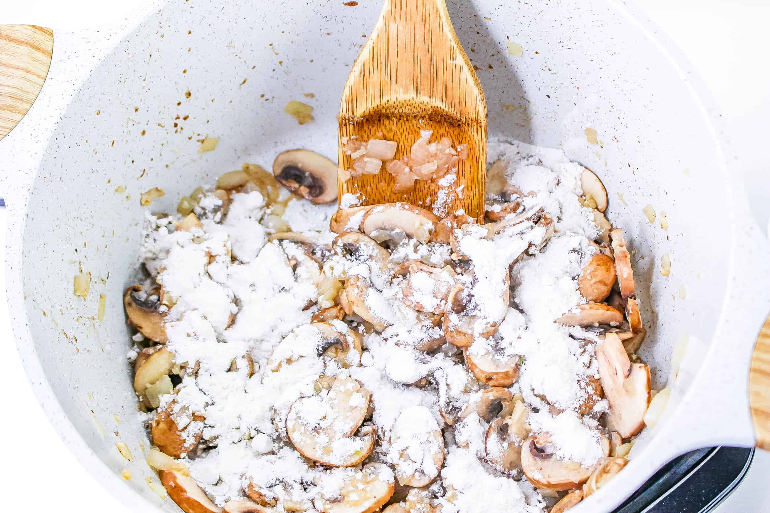 Flour sprinkled over the vegetables in the Dutch oven
