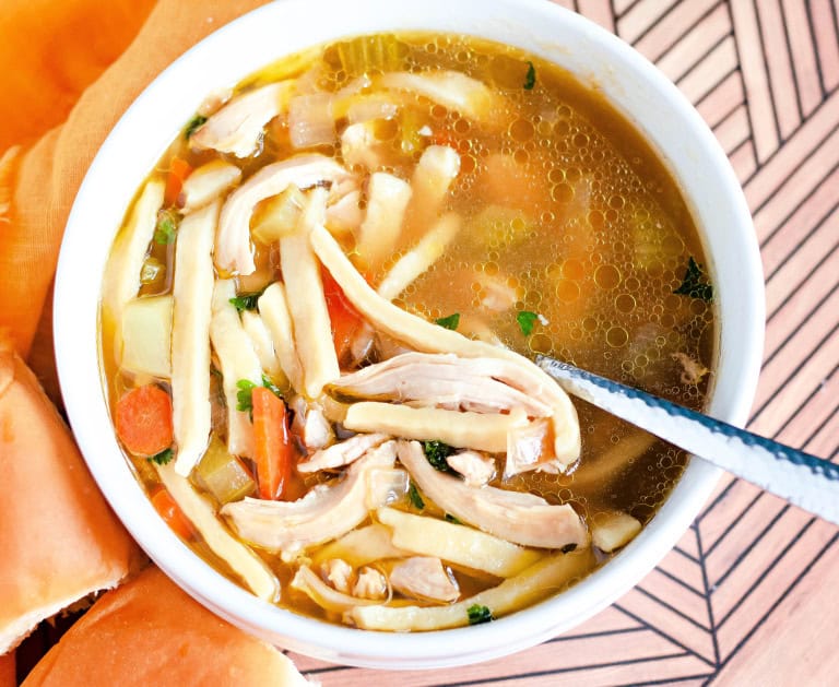 A bowl of gluten free chicken noodle soup in white bowl