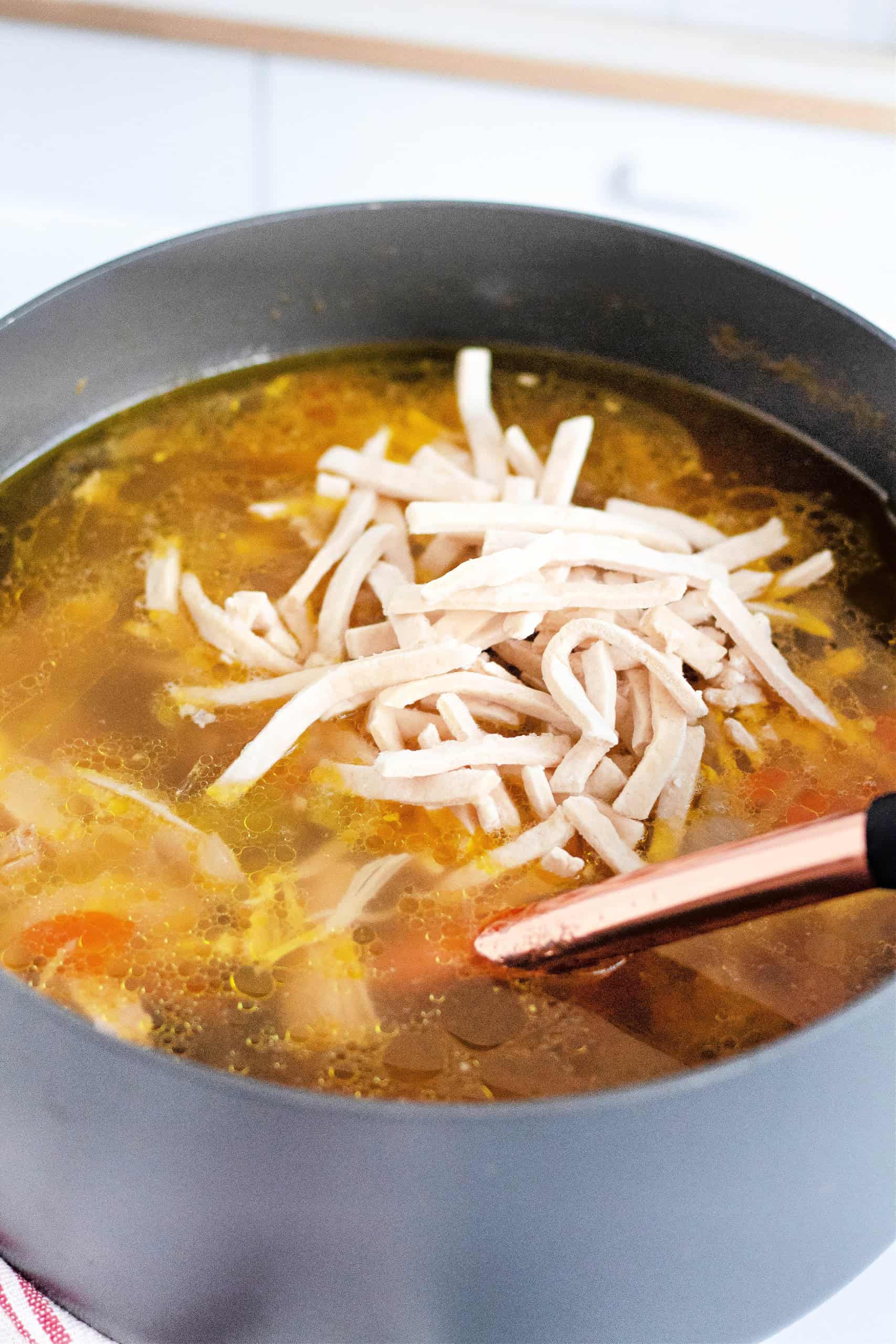 Noodles being added to the soup mixture