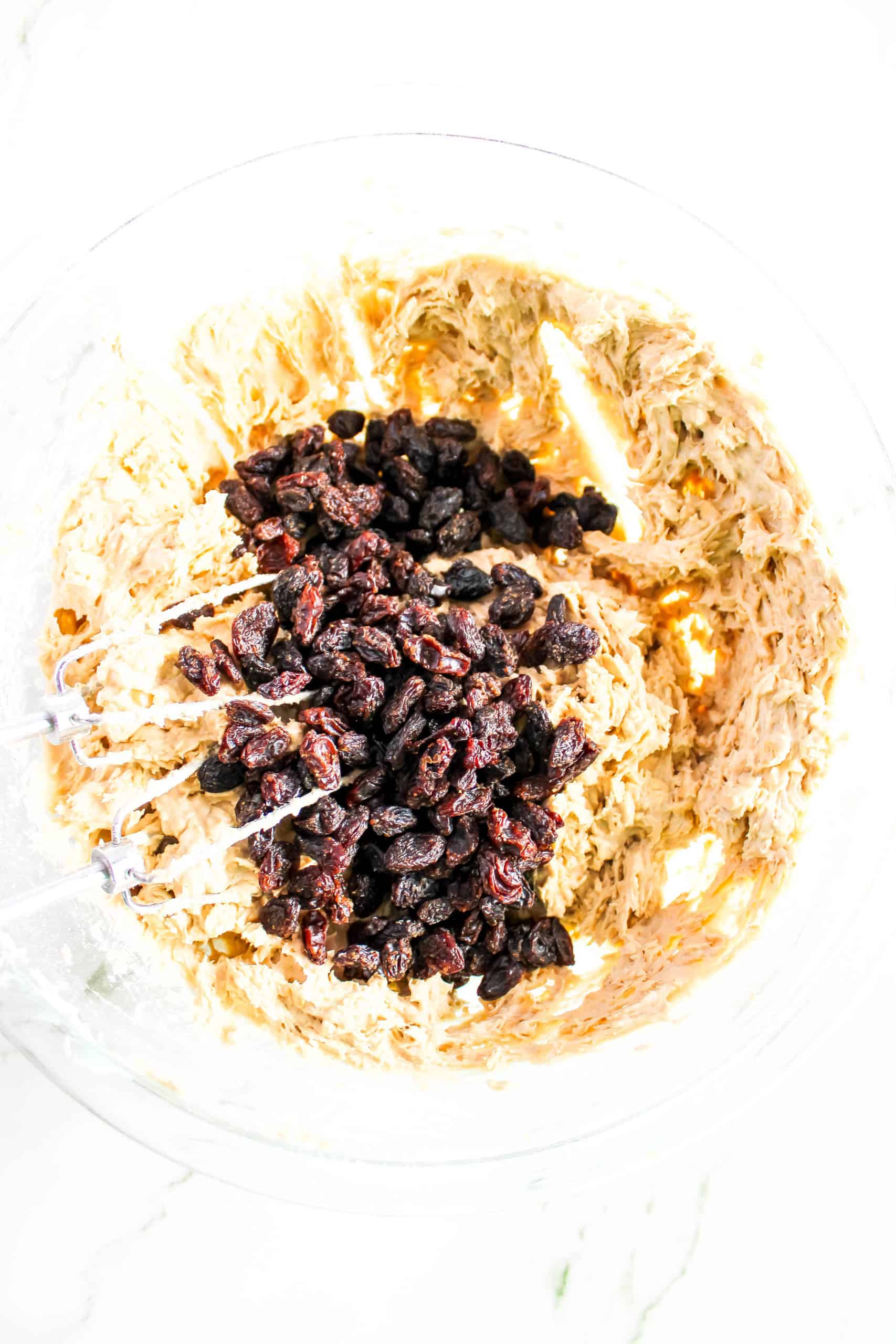 The dry ingredients along with the raisins combined with the other ingredients in the glass bowl.