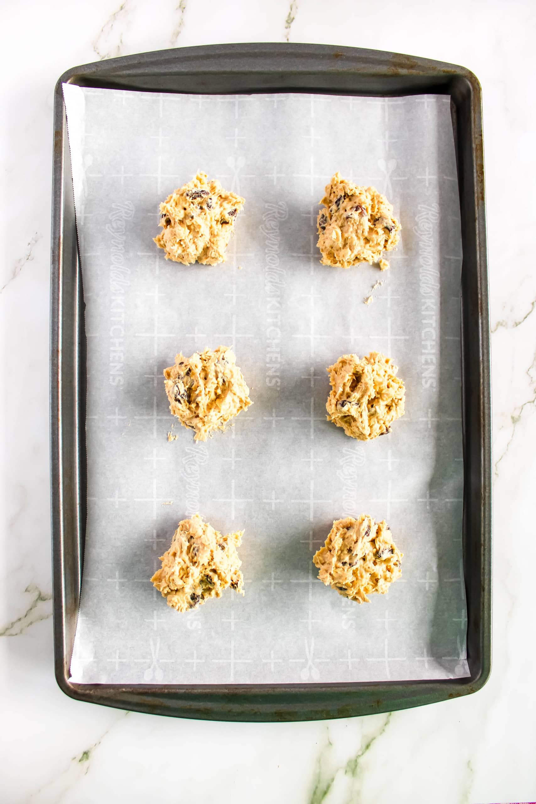 Cookies on baking sheet to be placed in oven to bake