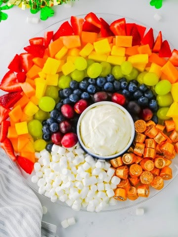 Rainbow fruit tray with St. Patty's day shamrock decorations around it