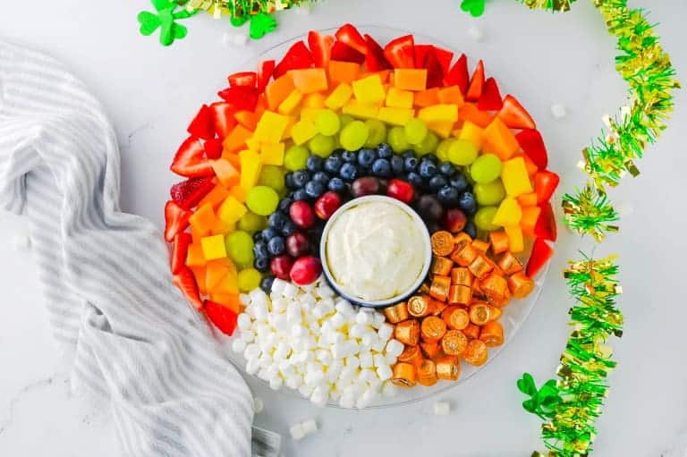 Rainbow fruit tray with St. Patty's day shamrock decorations around it