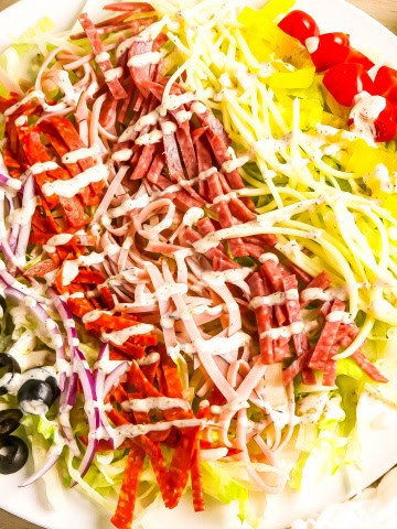 White plate with grinder salad