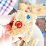 A gluten free patriotic bar in a hand being lifted off a plate.