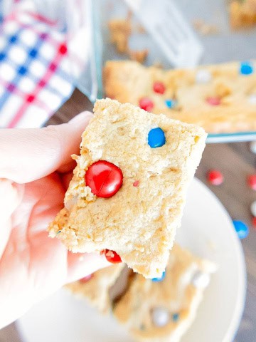 A gluten free patriotic bar in a hand being lifted off a plate.