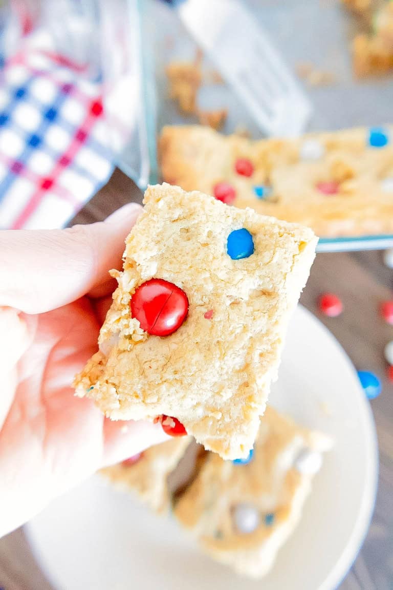 A gluten free patriotic bar in a hand being lifted off a plate.